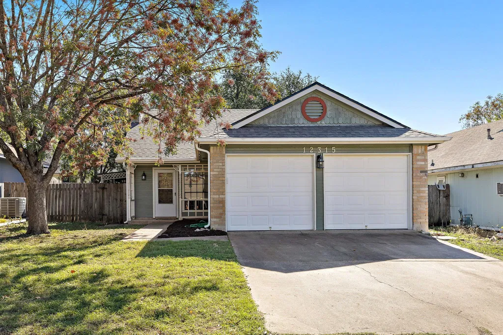 The original home: a single-story suburban house with a front-facing two-car garage and a mature shade tree